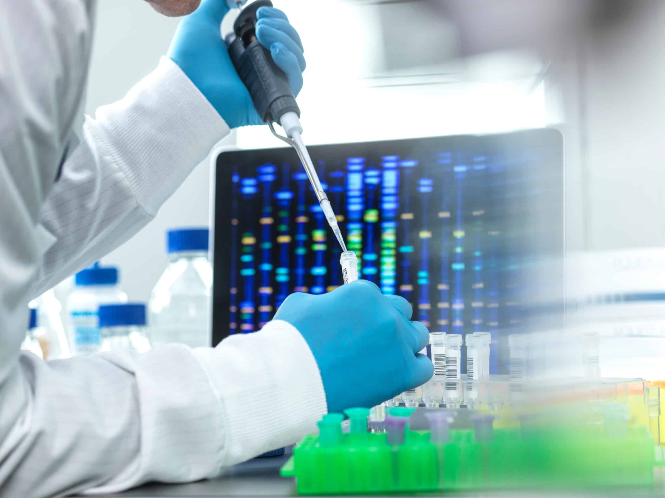 Scientist in front of a computer with a test tube in a lab